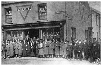 This photograph of a group of soldiers standing outside the Aberdare YMCA building was taken during the First World War. The YMCA building was located at 23 Commercial Street on the corner with Gloucester Street