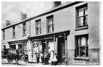 In the photograph above/right David Edwards stands proudly on the doorstep of his store at 19 Bwllfa Road in this photograph from the early Twentieth Century. In 1920 the store was described as a grocer, draper & boot & shoe warehouse. The store also contained the village Post Office where Islwyn Edwards was the Sub-Postmaster