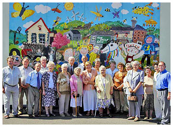 In 2004 the school celebrated its 100th anniversary and this picture shows the present headmaster with past pupils stood in front of a mural on the school depicting the past, present and future.